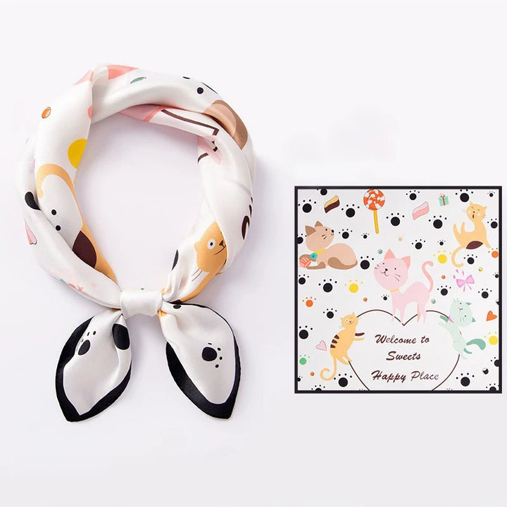 AuraOrient 100% Mulberry silk square scarf shown tied and laid flat, featuring a playful cat print and a sleek black border.