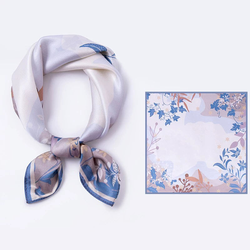 AuraOrient 100% Mulberry silk square scarf shown tied and laid flat, featuring elegant botanical vine motifs and a calming Wisteria Blue border.