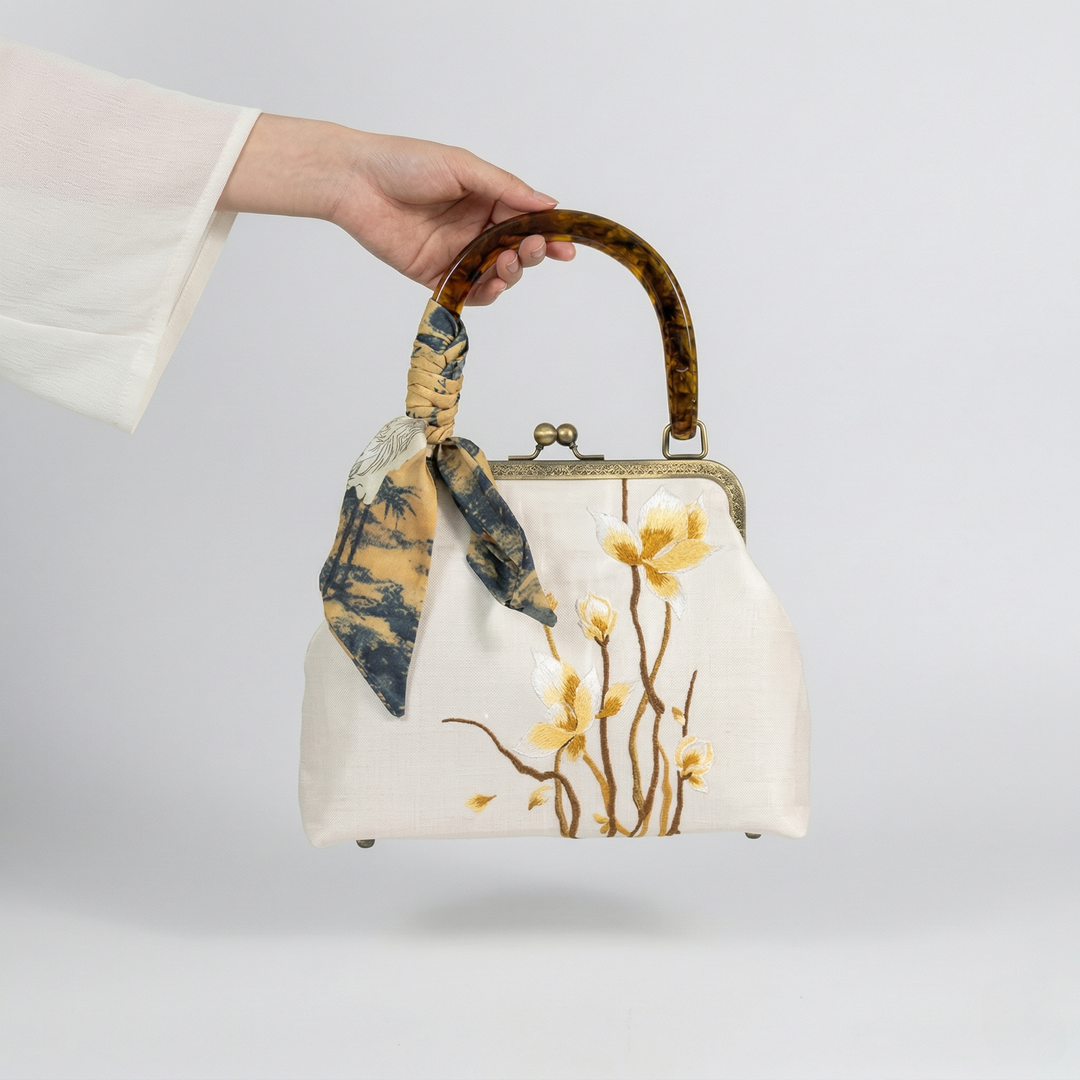 Elegant side view of the beige floral embroidered handbag with its silk scarf-wrapped bamboo handle.