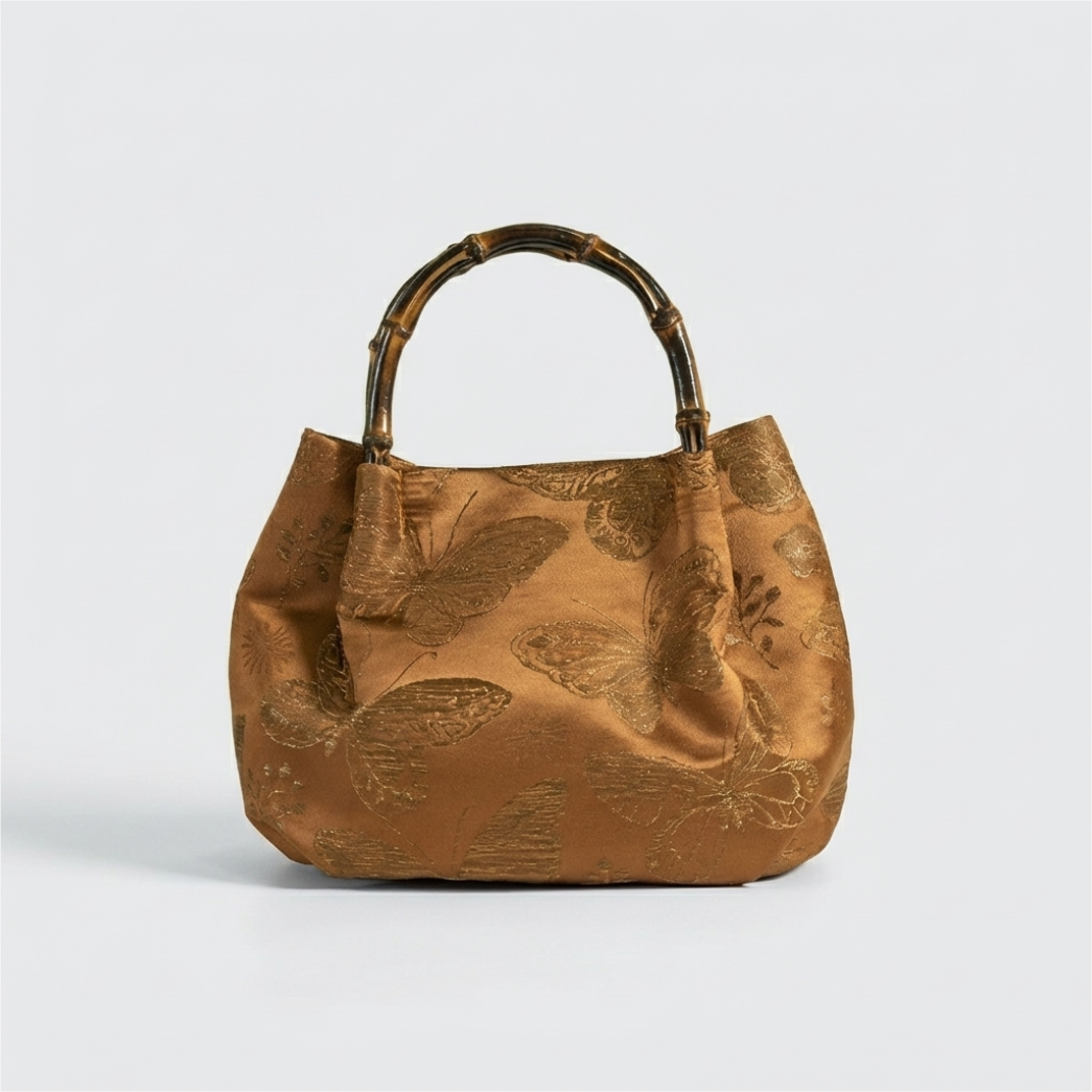 Vintage bronze brocade satchel with a classic bamboo handle and sophisticated Oriental floral motifs.