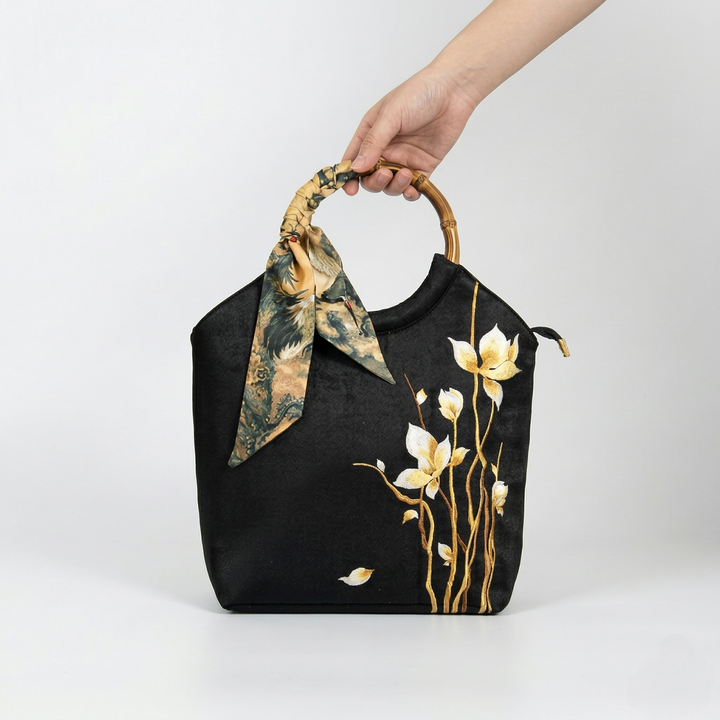 Close-up of a person holding the large black floral embroidered tote bag, demonstrating its elegant proportions.
