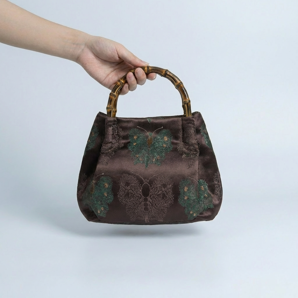 A person carrying the maroon Zen Garden bamboo satchel, perfect for weddings or cultural events.