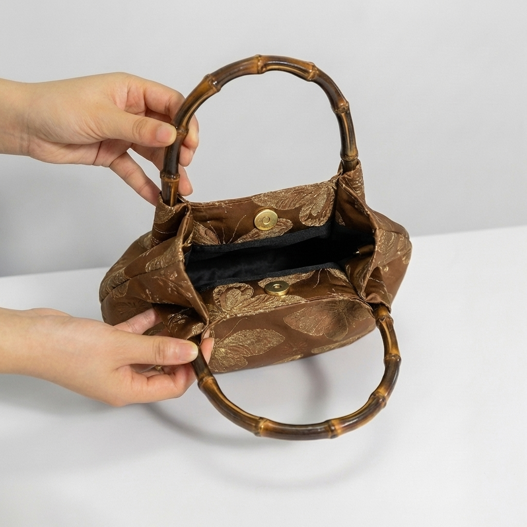 Opening the bronze bamboo handle bag by hand to show its spacious and practical interior.