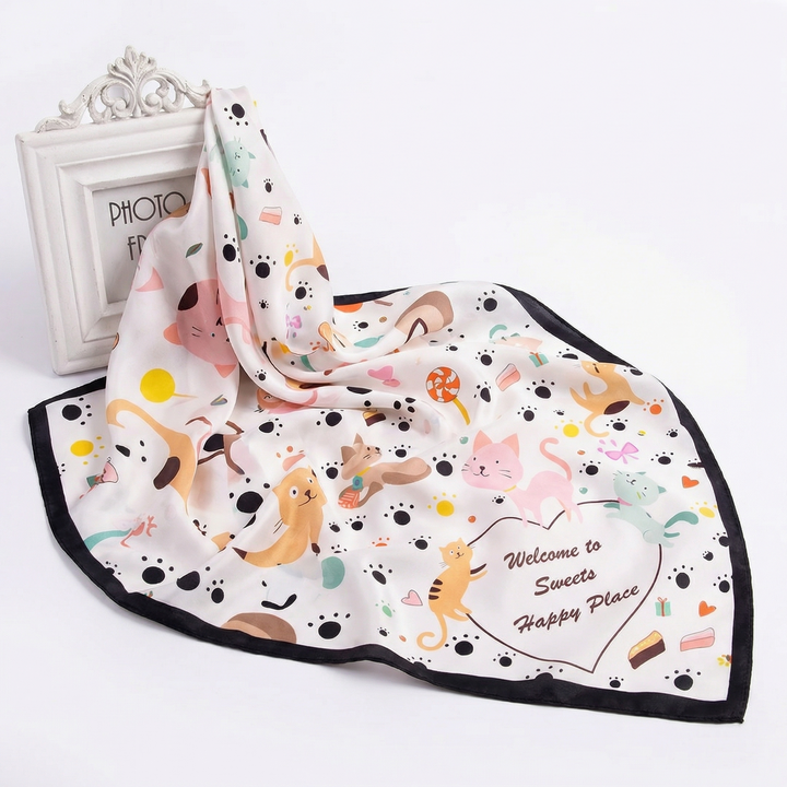 Elegantly draped pure silk neckerchief displaying a whimsical feline design and the words Welcome to Sweety Happy Place.