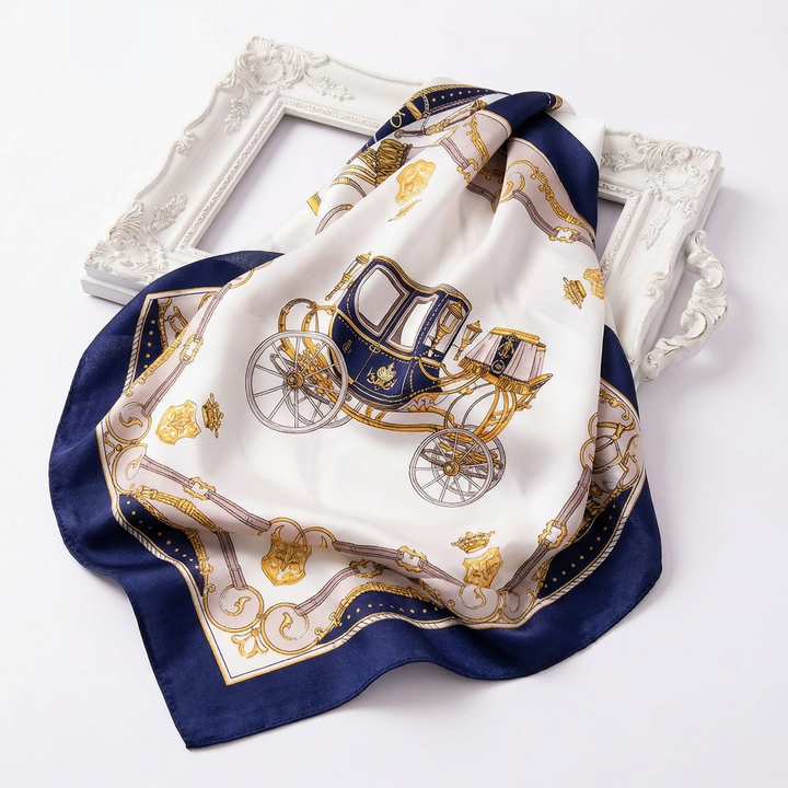Elegantly draped pure silk neckerchief displaying regal golden carriage illustrations on a vintage-style cream background with navy blue trim.