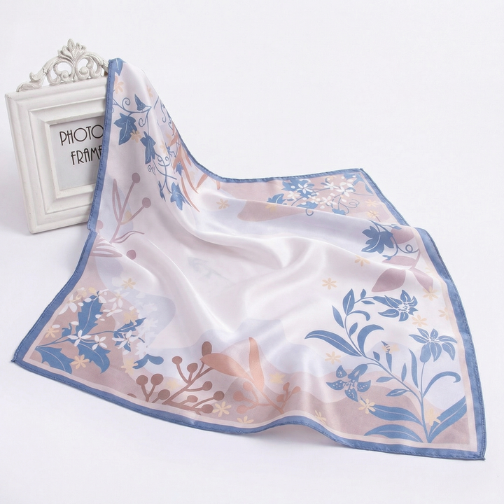 Elegantly draped pure silk neckerchief displaying delicate cascading vines and a soft periwinkle blue canvas.