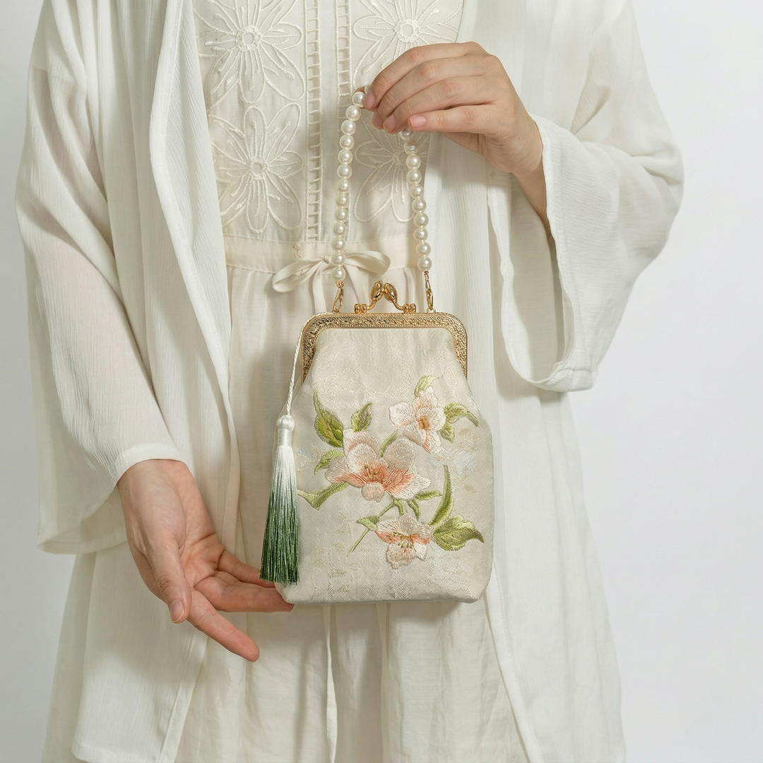 Elegant styling of the pearl-handle floral mini bag, shown as a sophisticated accessory for cultural events.