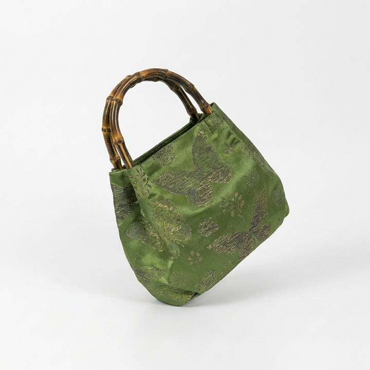 Side profile of the green floral satchel showcasing the high-quality brocade fabric and bamboo handle.