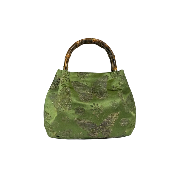 Front view of the green floral brocade satchel with a natural bamboo handle for a Zen-inspired style.