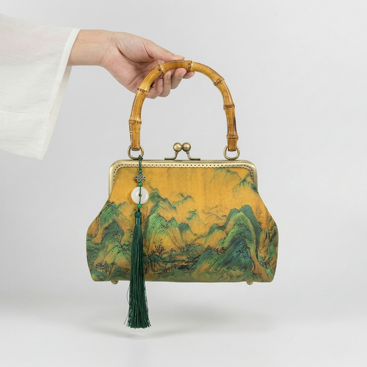 Close-up of a person holding the Oriental art-inspired handbag by its authentic bamboo handle, showcasing its elegant proportions.