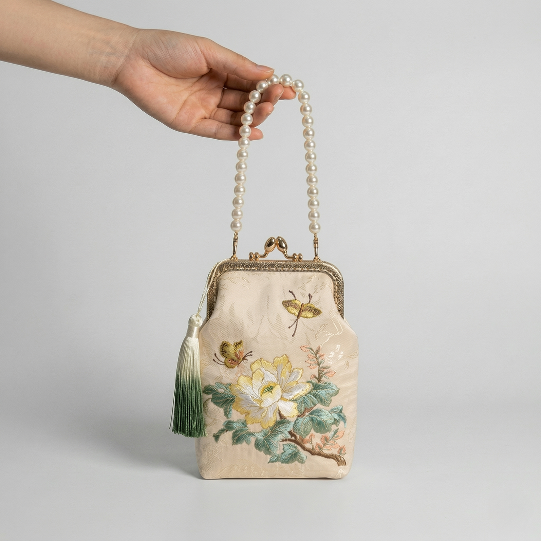 Demonstrating the hand-carried style of the mini floral bag using its elegant pearl top handle.