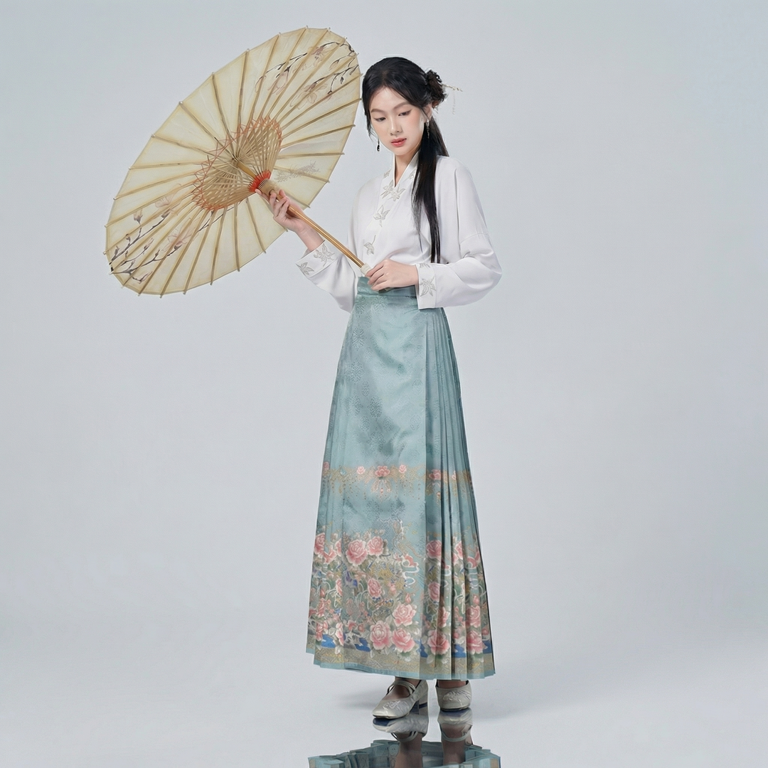 Model wearing the romantic pastel floral pleated skirt and wrap top, holding a traditional paper umbrella for a sophisticated cultural heritage look.