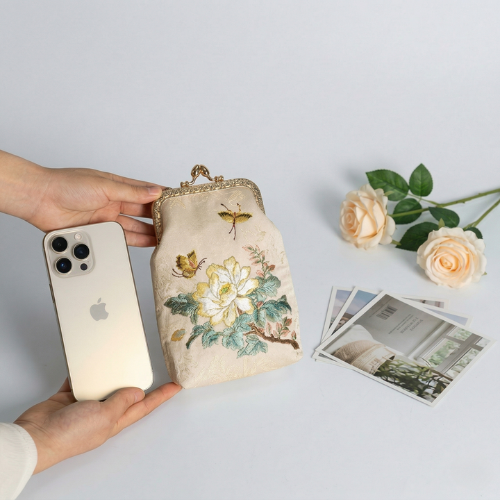 Size comparison of the mini kiss-lock bag next to a smartphone, showing its perfect fit for daily essentials.