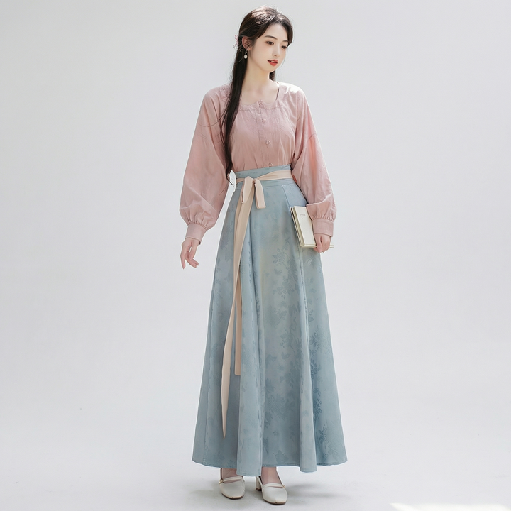 Full-length view of a modern Chinoiserie coord set featuring a pastel pink lantern sleeve blouse and a stunning dusk blue floral jacquard maxi skirt.