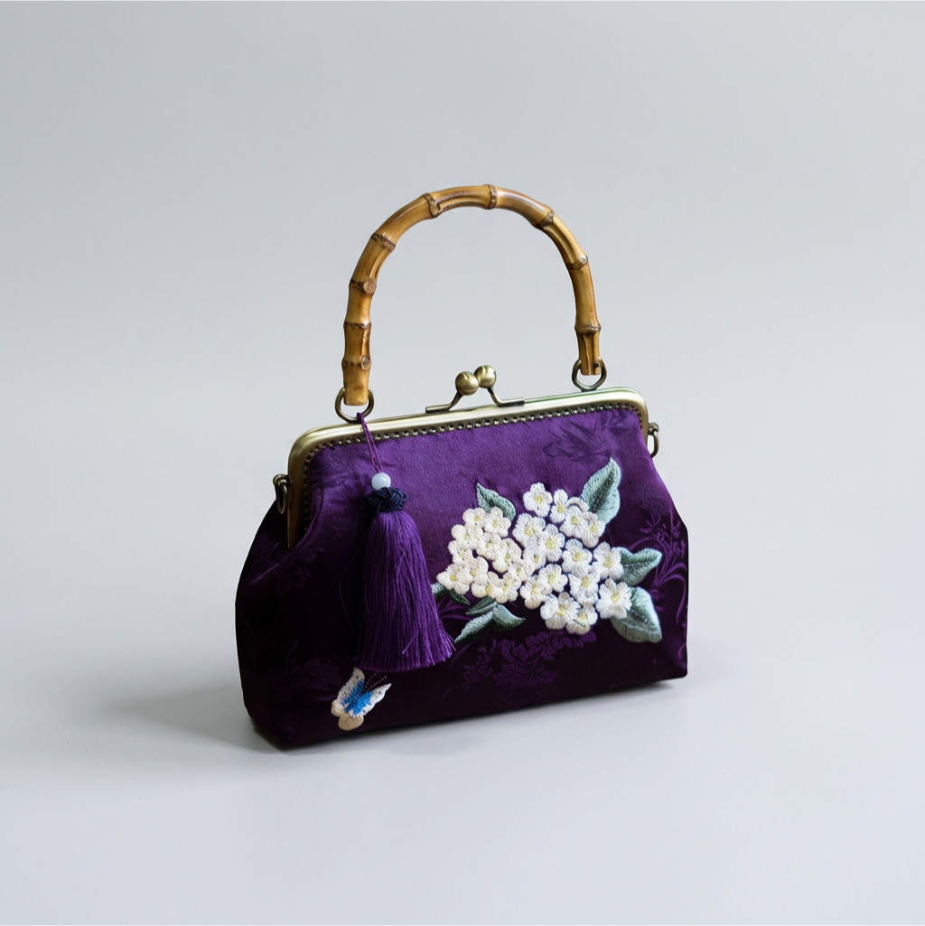 Elegant purple silk bag with white floral embroidery and a unique bamboo handle for a natural touch.