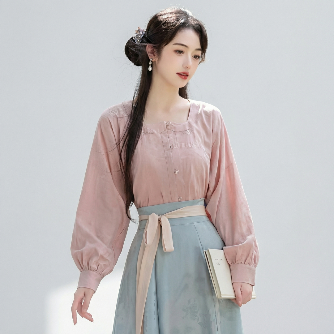 Mid-shot of the delicate pastel pink blouse with graceful lantern sleeves, highlighting the romantic and refined vintage-inspired design.