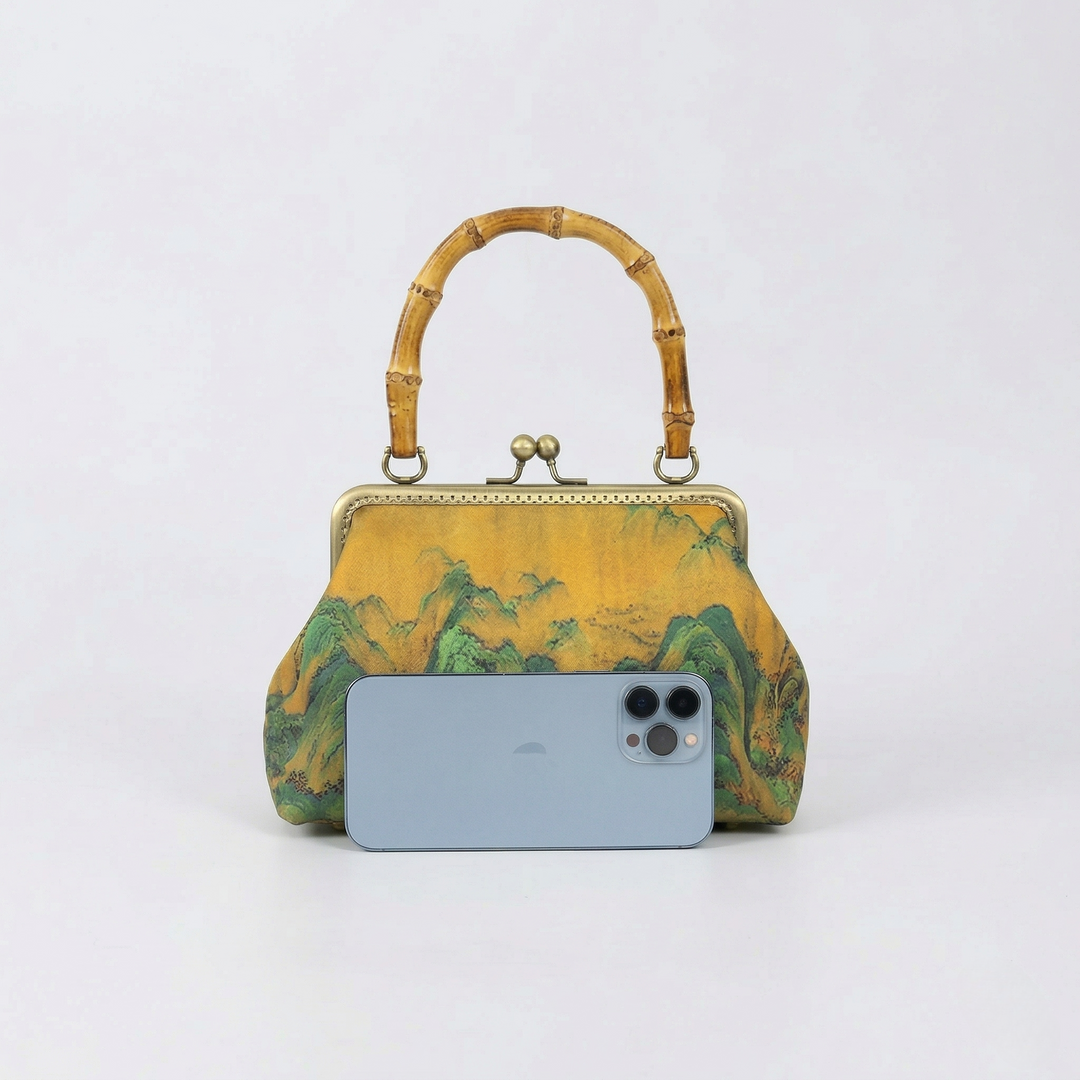 Size comparison of the Oriental landscape handbag next to a smartphone to demonstrate its practical daily carrying capacity.