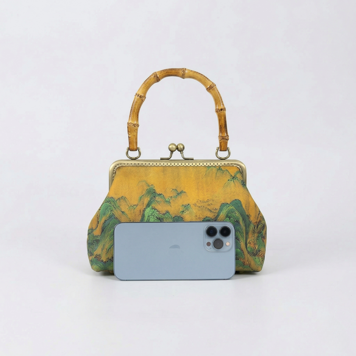 Size comparison of the Oriental landscape handbag next to a smartphone to demonstrate its practical daily carrying capacity.
