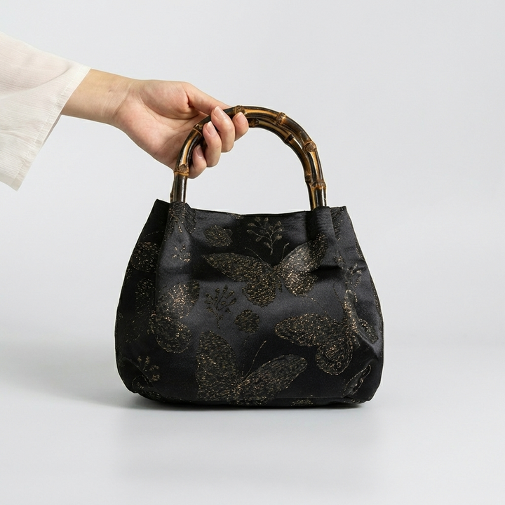 Styling the black butterfly brocade bamboo bag as a sophisticated and unique handheld accessory.
