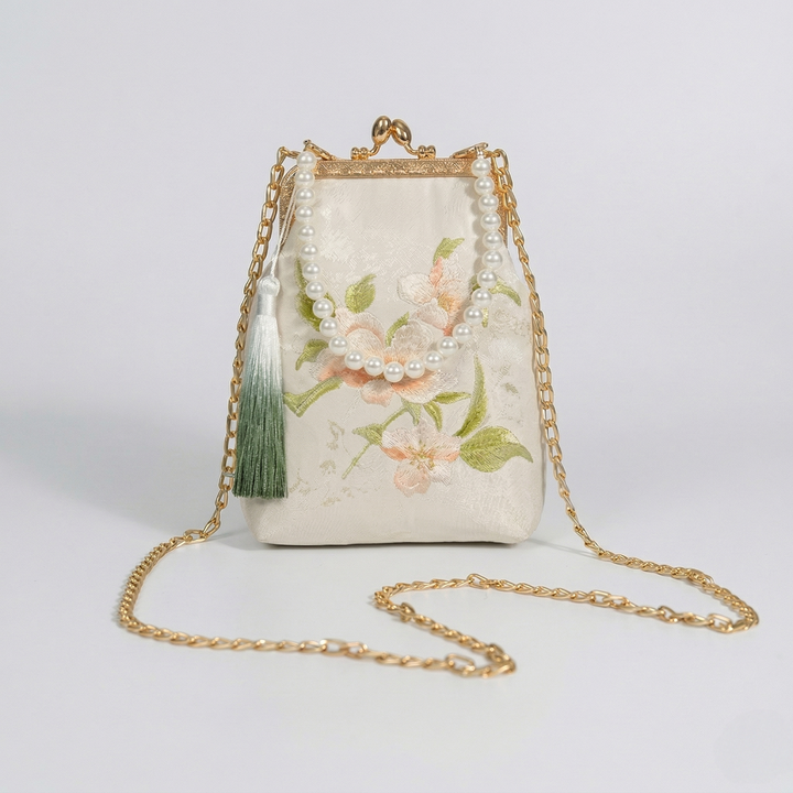 Side perspective of the vintage-style floral embroidered mini bag, showcasing its elegant shape as an evening clutch.